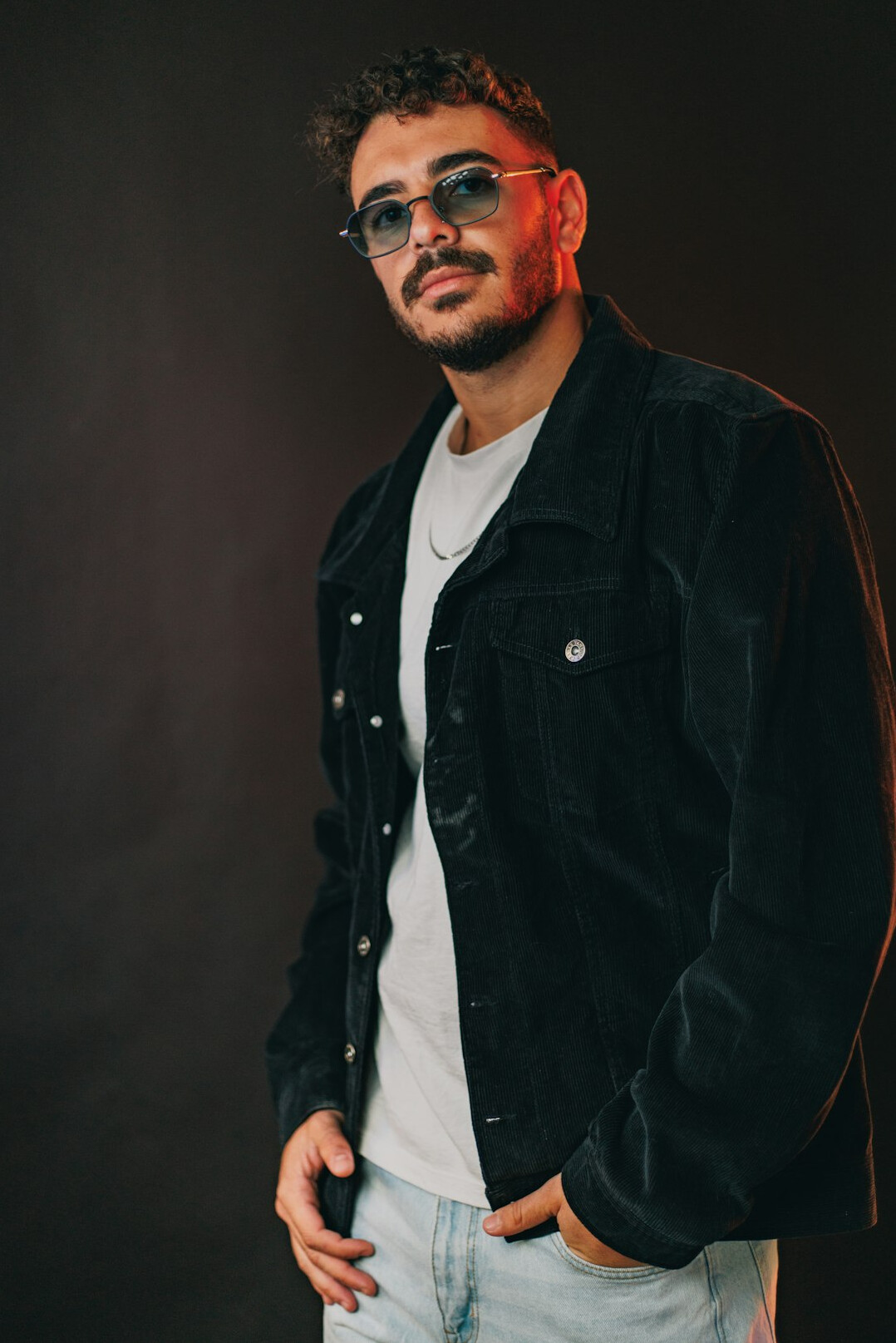 Latino man with glasses in a casual studio portrait