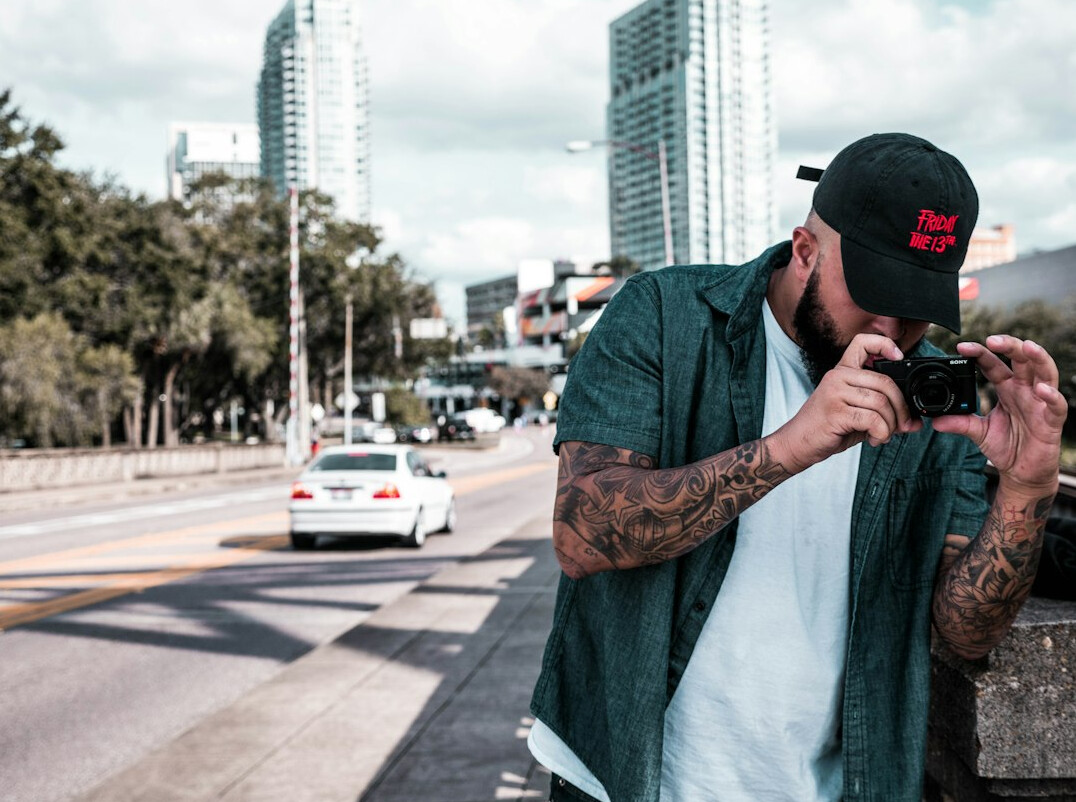 Latino male street photographer holding a camera