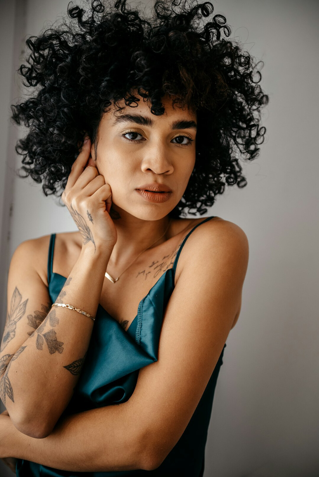 Latina woman with curly hair smiling in a studio portrait