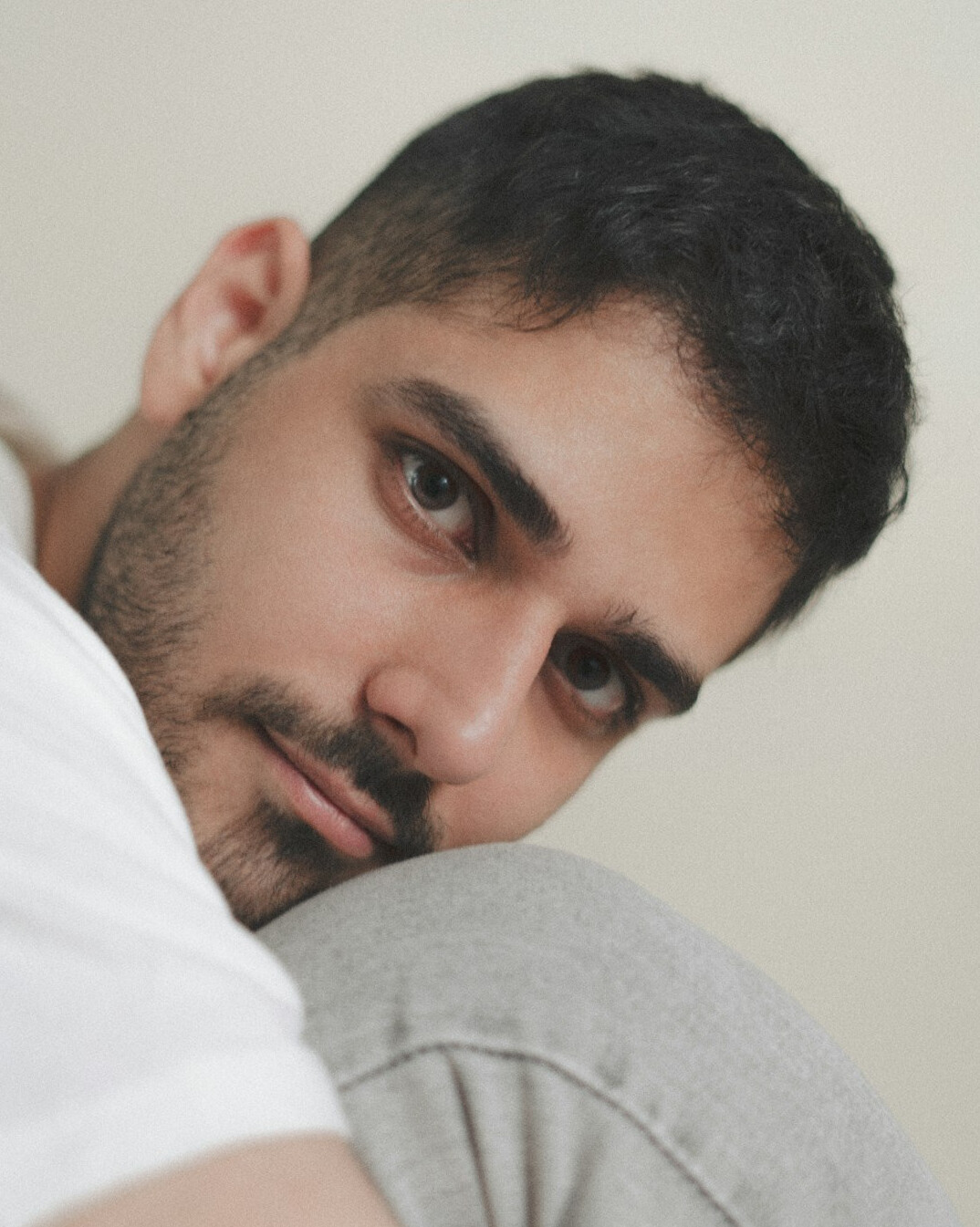 Latino man with short beard smiling in a studio portrait